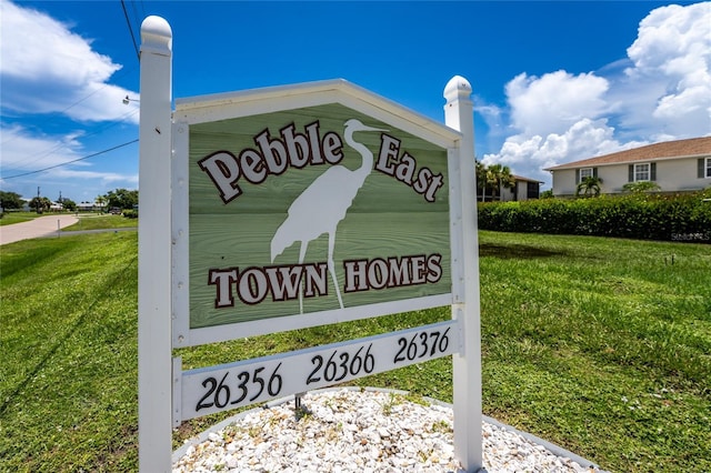 community sign featuring a lawn