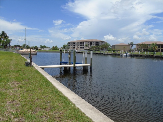 view of dock with a yard and a water view