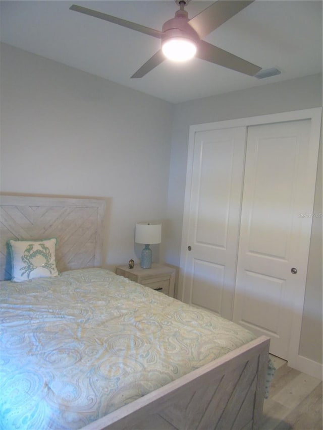 bedroom featuring ceiling fan, light hardwood / wood-style floors, and a closet