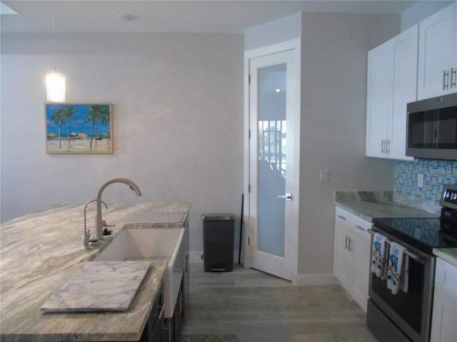 kitchen with sink, hanging light fixtures, stainless steel appliances, backsplash, and white cabinets