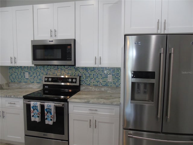 kitchen featuring stainless steel appliances, decorative backsplash, and white cabinetry