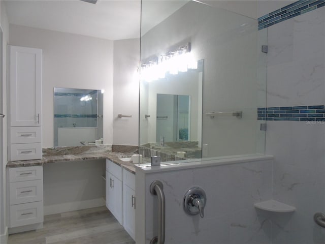 bathroom with an enclosed shower, wood finished floors, and vanity