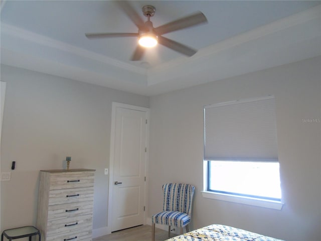 bedroom featuring a raised ceiling and a ceiling fan