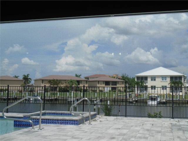 community pool with a residential view and a hot tub