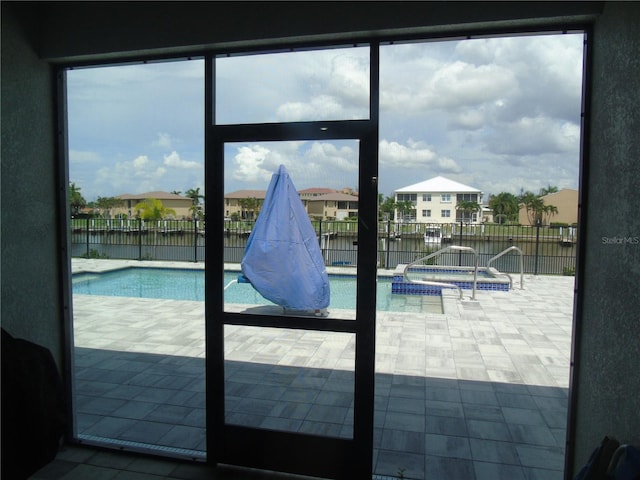 view of swimming pool featuring a water view and a pool with connected hot tub