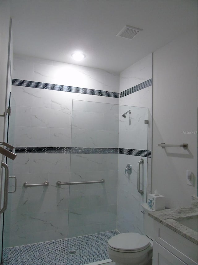 bathroom with vanity, an enclosed shower, and toilet