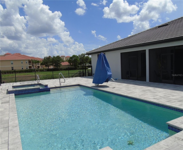 view of swimming pool featuring a patio area, a pool with connected hot tub, fence, and a sunroom