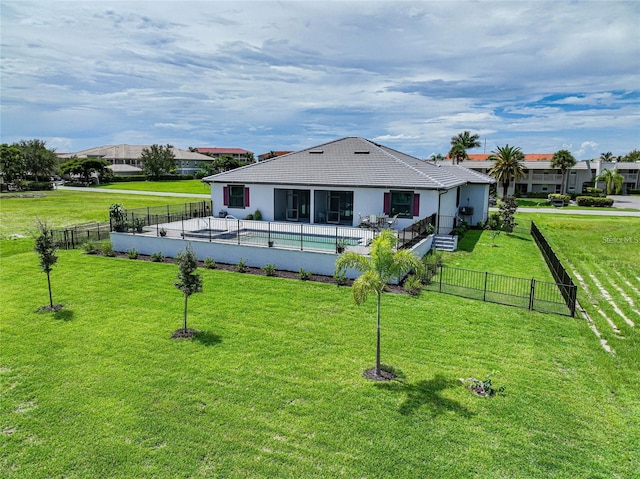 rear view of house featuring a fenced backyard, a tile roof, and a yard
