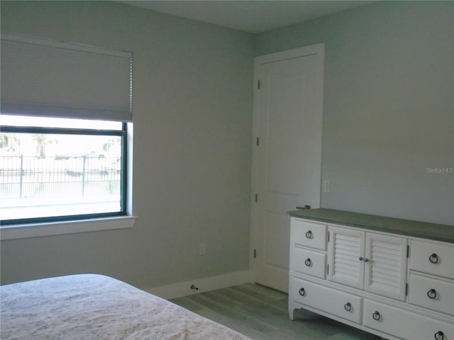 unfurnished bedroom with light wood-style flooring and baseboards