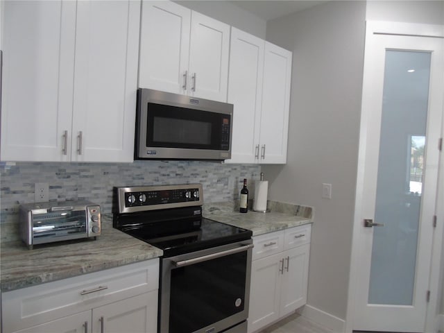kitchen featuring backsplash, white cabinetry, and appliances with stainless steel finishes