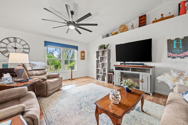 living room with lofted ceiling, ceiling fan, and light wood-type flooring