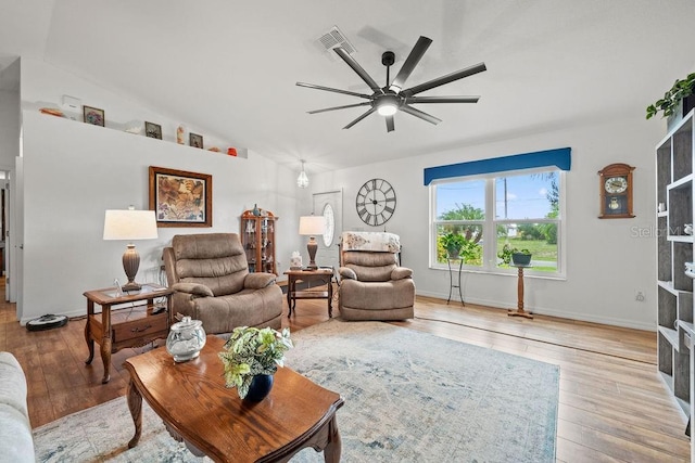 living room featuring ceiling fan, vaulted ceiling, and light wood-type flooring