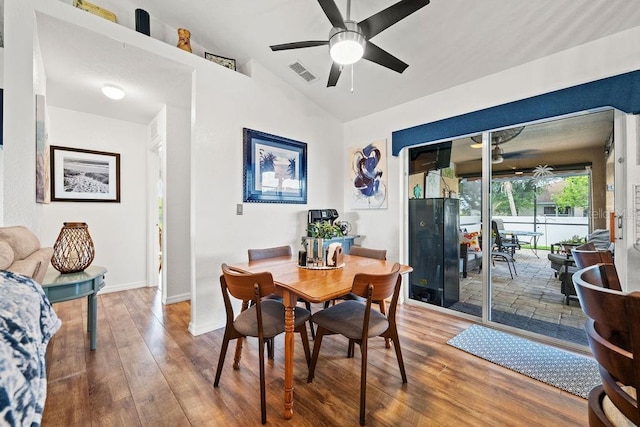 dining space featuring wood-type flooring, vaulted ceiling, and ceiling fan