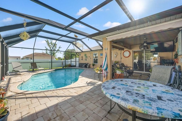 view of swimming pool with ceiling fan, a lanai, and a patio area