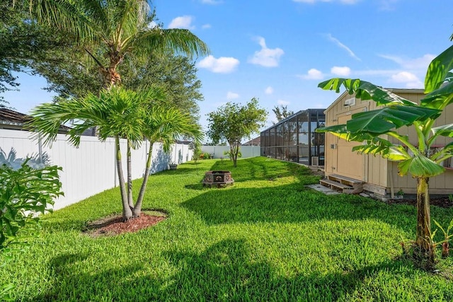 view of yard with a lanai and an outdoor fire pit