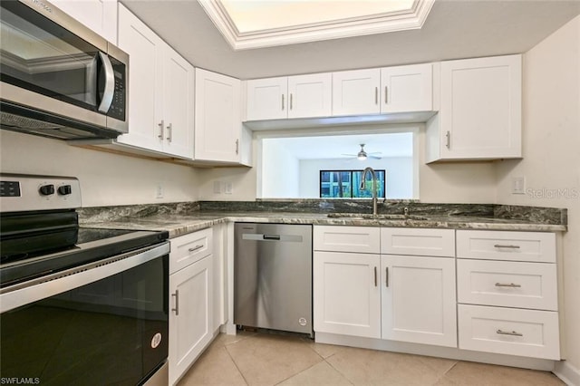 kitchen with crown molding, stainless steel appliances, light tile floors, sink, and white cabinets