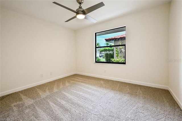 carpeted spare room featuring ceiling fan