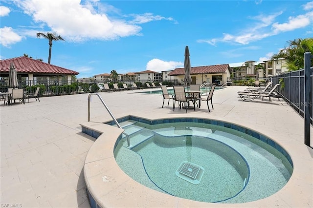 view of swimming pool with a patio area and a hot tub