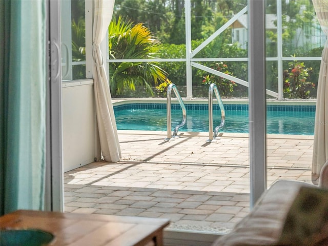 view of swimming pool with glass enclosure and a patio area