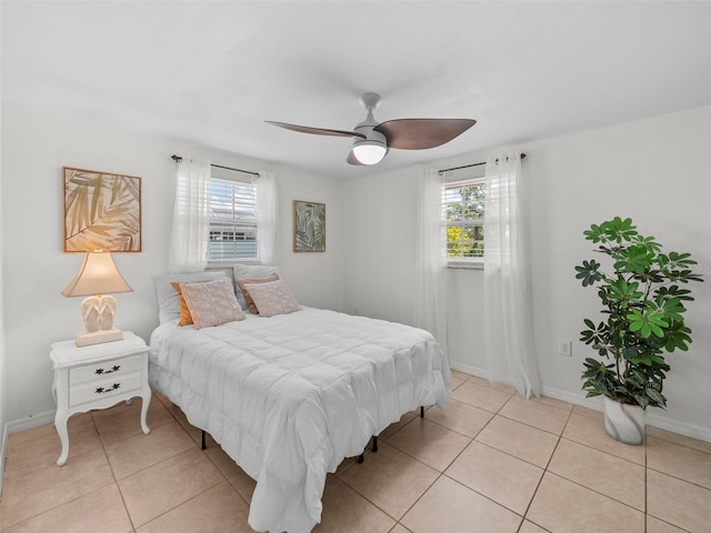 bedroom with multiple windows, light tile patterned flooring, and ceiling fan