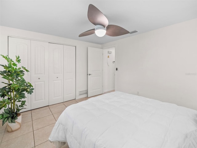 bedroom featuring ceiling fan, a closet, and light tile patterned floors