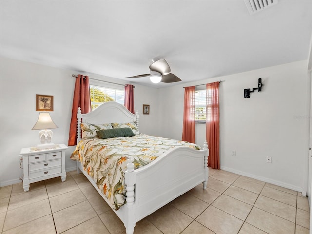 bedroom with multiple windows, light tile patterned floors, and ceiling fan