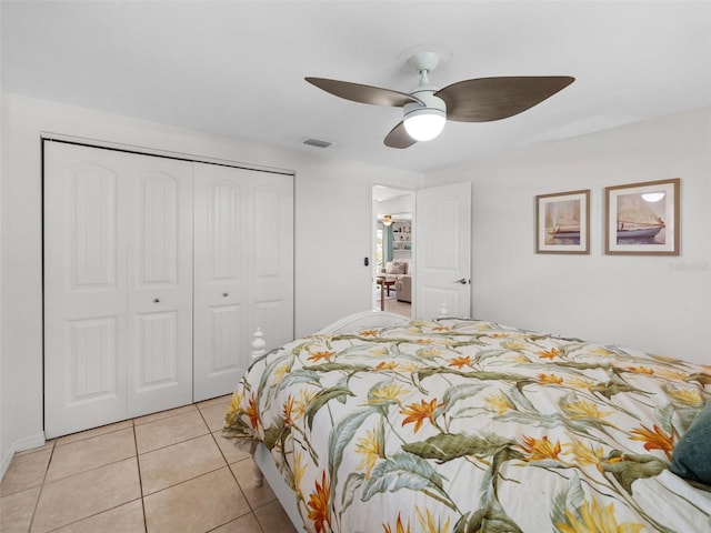 tiled bedroom with ceiling fan and a closet