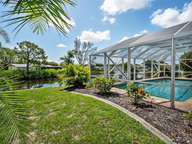 view of swimming pool with a water view, a yard, and a lanai