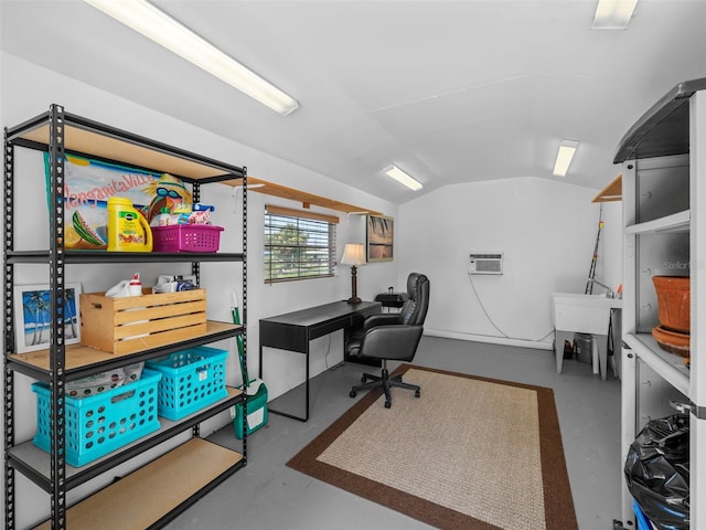 office featuring vaulted ceiling, a wall unit AC, and concrete floors