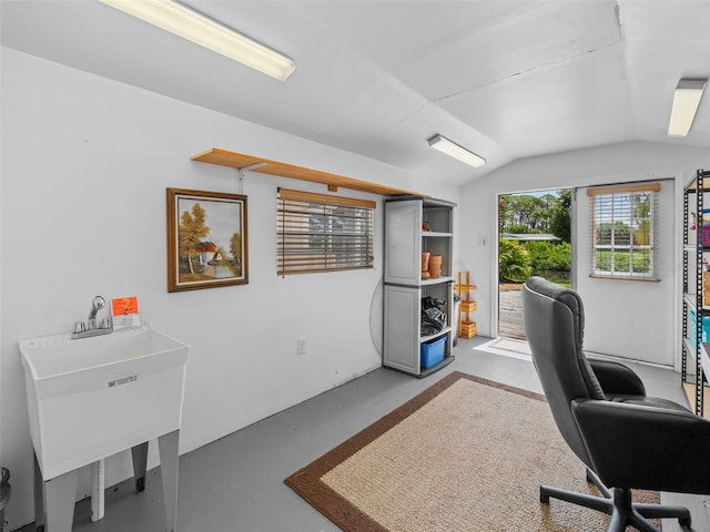 office featuring sink, vaulted ceiling, and concrete floors