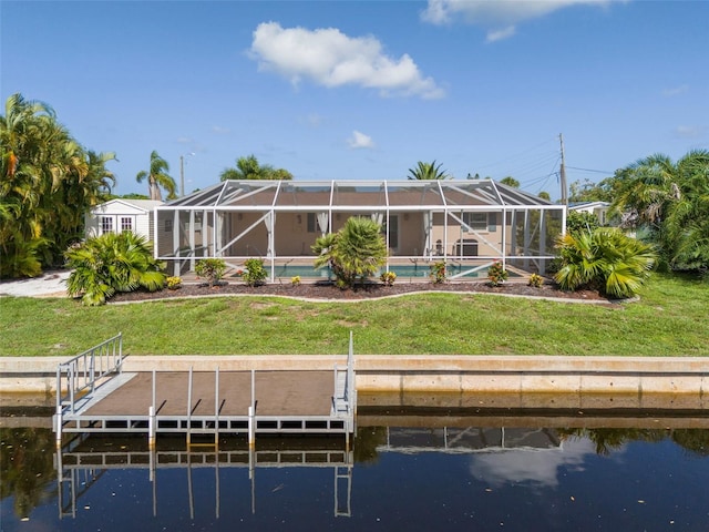 back of house featuring a lawn, a water view, and glass enclosure