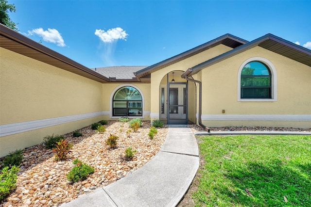 doorway to property with a lawn