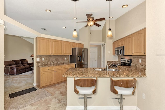 kitchen featuring stainless steel appliances, sink, hanging light fixtures, decorative backsplash, and ceiling fan