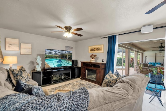 living room with ceiling fan and a textured ceiling