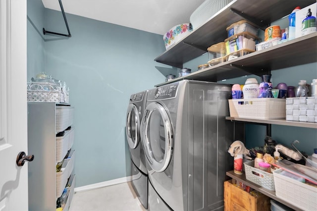 laundry area featuring light tile patterned flooring and washing machine and dryer