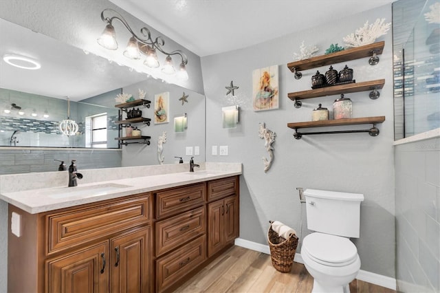 bathroom with hardwood / wood-style flooring, vanity, toilet, and walk in shower