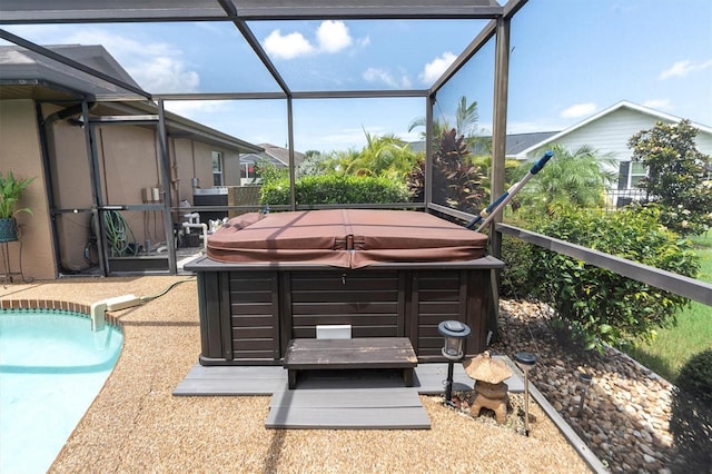 view of patio / terrace with a pool with hot tub and glass enclosure