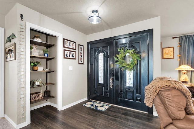 foyer featuring wood finished floors and baseboards