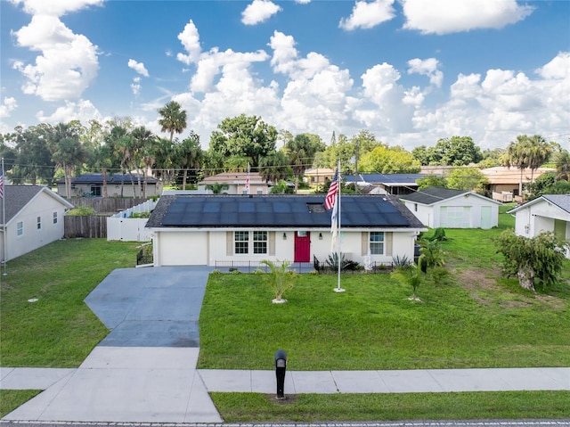 ranch-style house with a front yard, solar panels, and a garage