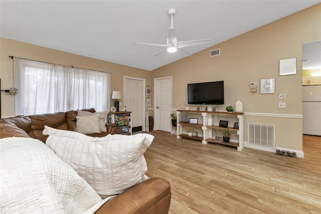 living room with ceiling fan, light hardwood / wood-style floors, and lofted ceiling