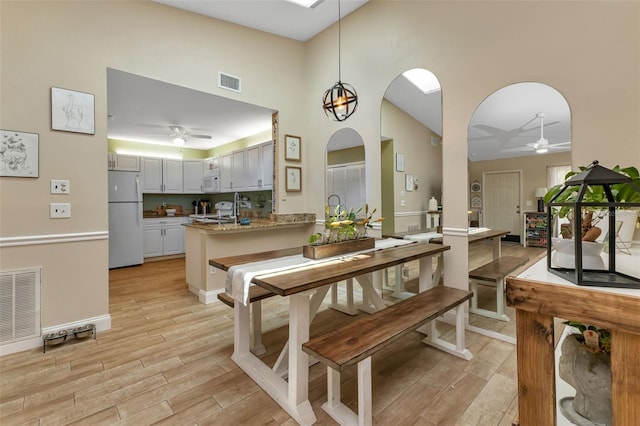 dining area with ceiling fan and a high ceiling