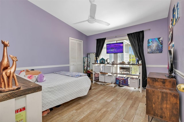 bedroom with a closet, vaulted ceiling, ceiling fan, and hardwood / wood-style flooring