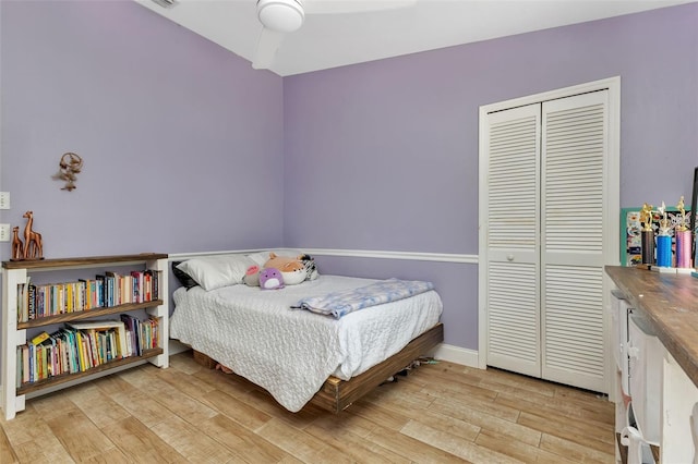 bedroom with ceiling fan, a closet, and light wood-type flooring