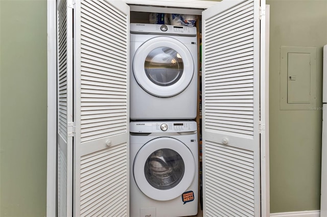 laundry area featuring electric panel and stacked washer and dryer