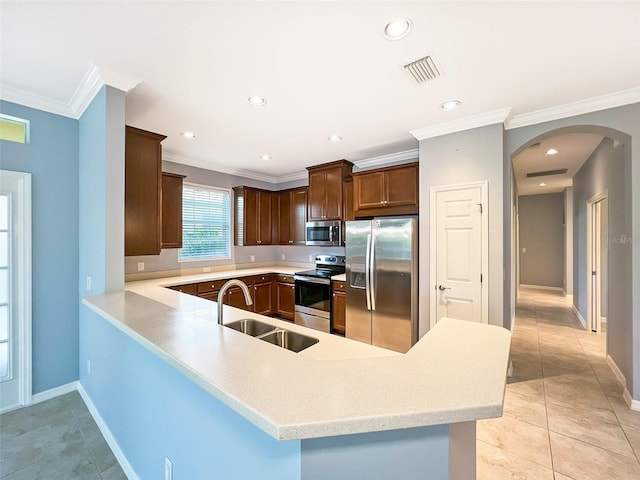 kitchen featuring crown molding, sink, light tile patterned floors, appliances with stainless steel finishes, and kitchen peninsula