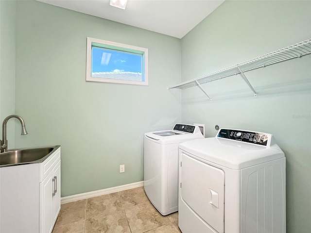 clothes washing area featuring cabinets, washing machine and dryer, and sink