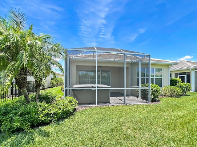 back of property featuring ceiling fan, a lanai, a yard, and a patio