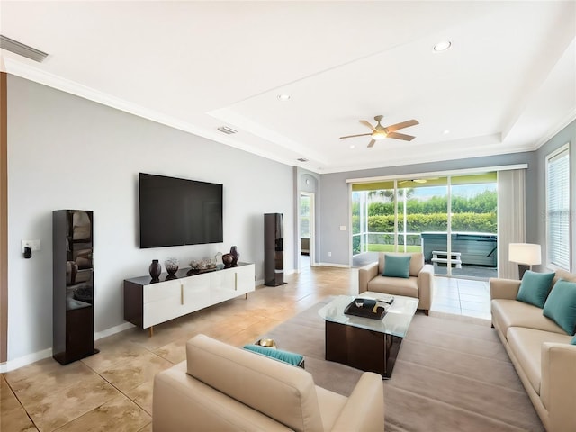 living room featuring a tray ceiling, ceiling fan, and light tile patterned flooring