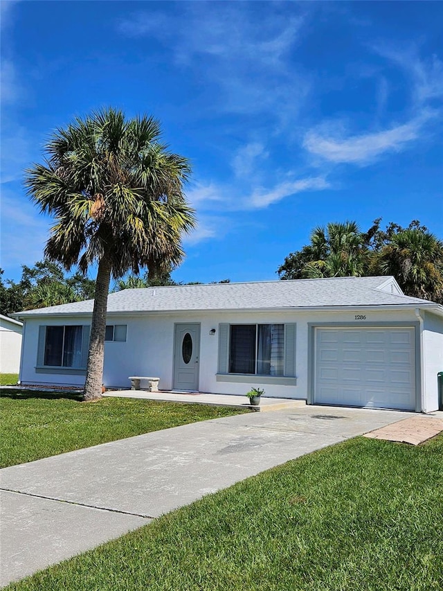 ranch-style home with a garage and a front lawn