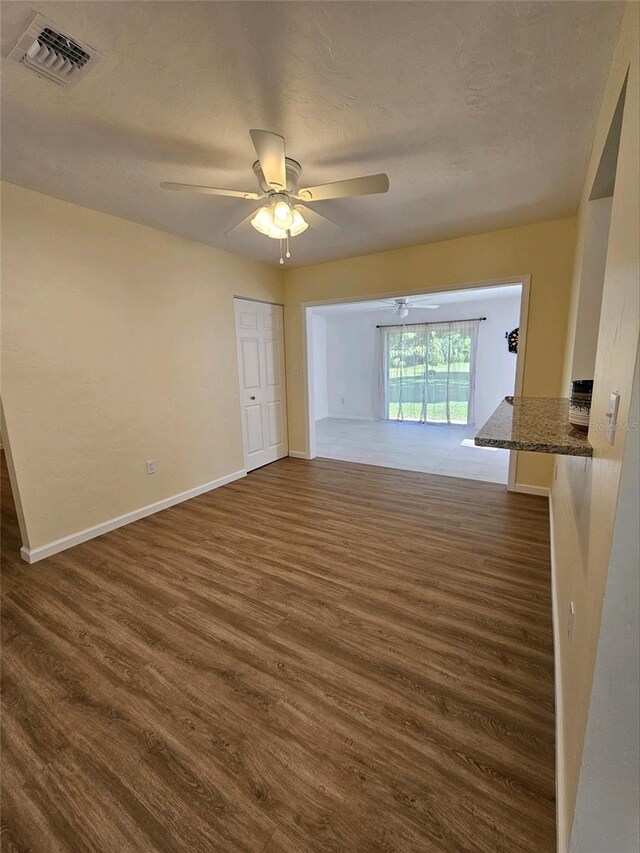 spare room featuring ceiling fan, dark hardwood / wood-style flooring, and a textured ceiling